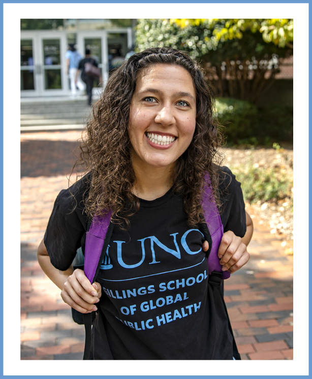 Photo of female student outside, smiling and wearing a t-shirth with UNC Gilllings School of Global Public Health logo and purple backpack. The photo has a thin Carolina Blue border around it, with a blank space between the photo and border.